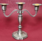 Candelabro espessurado a prata com três pontas para velas medindo 20x23 cm.