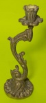 Castiçal em bronze com base redonda e haste curvada medindo 22 cm.