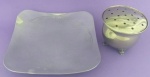 Centro de mesa em aço escovado trabalhado com pés medindo 22x22 cm.E mini floreira em metal prateado com quatro pés trabalhados medindo 12x9 cm.