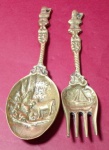 Colher e garfo de parede em bronze com imagens de animais e veleiro  medindo 18 e 19 cm.