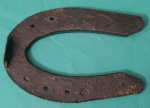 Ferradura em metal pesado medindo 13x9 cm.
