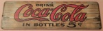 Placa vintage decorativa em madeira  retangular Coca-Cola medindo 33x10 cm.
