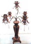 Candelabro com cinco braços para velas em metal e base em resina na cor cobre medindo 63x49 cm.
