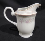 ANTIGA LEITEIRA COM DECORAÇÃO FLORAL E FILETADA A OURO EM PORCELANA SCHMIDT. MEDINDO 13 X 8.5 X 15 CM