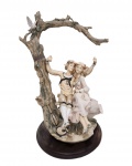ANTIGA ESCULTURA ITALIANA EM RESINA REPRESENTANDO CASAL NO BALANÇO COM BASE EM MADEIRA. COM RESTAURO. MEDINDO 39.5 X 29 X 28.5 CM