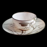 VISCONDE DE GUAHY  Xícara com pires de porcelana francesa. Borda da xícara de do pires com friso em ouro. Decoração com folhagens e coroa de visconde em ouro. No fundo marca do Ateliê de Paul Blot, da 3 rue de la Paix, em Paris. França. Séc. XIX. 3 x 6 cm (xícara). 11.5 cm. Apresenta bicado no fundo da xicara.