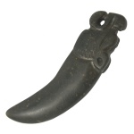 Antigo e raro artefato chinês em jade preto, representando raspador de peles e couros, de formato recurvo, rematado por cabeça de felino finamente esculpida. Possíveis infiltrações calcificadas. 10 x 3 cm.
