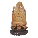 Rara e delicada escultura chinesa em marfim representando KwanYin, a deusa budista da misericórdia e compaixão. Exibe-se finamente esculpida, em atitude de meditação, com as mãos em oração, as pernas cruzadas sobre trono revestido por folhas de lotus. Base com 3 largos pés lavrados em volutas. Nota-se a rica e sofisticada pátina em tons alaranjados, devida à idade da escultura. Acompanha base em madeira de fabricação posterior. Dinastia Ming (1368-1644).17,50 cm (MT). 14,20 cm (escultura).