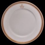 IMPÉRIO BRASILEIRO. Viscondessa de Ubá - Prato em porcelana francesa de Limoges pertencente ao Serviço da Viscondessa de Ubá (Dona Mariana Velho de Avellar), importante nobre da aristocracia do Brasil Império. Traz as iniciais entrelaçadas de Mariana Velho de Avellar estilizadas em ouro na parte superior da caldeira. Borda elegantemente ornamentada com padrões de gregas e filetes dourados. Dona Mariana tornou-se viscondessa em 1887. 20 cm.