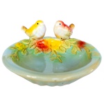 Vide poche em cerâmica esmaltada caracterizada por seu design lúdico. Formato circular que remete a uma flor desabrochada, com um relevo central imitando o miolo de um girassol e dois passarinhos esculpidos na borda ao lado de uma flor amarela aplicada em alto-relevo. 6 x 14 cm.