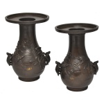 Séc. XIX - Par de vasos orientais, provavelmente japoneses, em bronze patinado, de formato balaústre, ornamentados por pássaros e folhagens em relevo. Bojos piriformes, ladeados por pegas no formato de tartarugas. Gargalos retos rematados por largas bordas salientes. Bases circulares lisas. 18 x 12 cm.