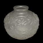 Vaso esférico em grosso cristal transparente, ornamentado em relevo por florões sobre fundo texturizado. Parte superior realçada por friso recortado com finos fomos. Gargalo retraído e borda reta.13 x 15 cm.