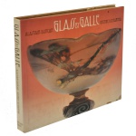 "Glass by Gallé", uma das obras de referência mais importantes sobre os vidros artísticos do designer francês Émile Gallé, por Alastair Duncan e Georges de Bartha, renomados especialistas em artes decorativas do período. Lançado originalmente em 1984 pela Harry N. Abrams (EUA) e pela Thames & Hudson (Reino Unido). Possui 223 páginas repleta de ilustrações monocromáticas e coloridas detalhando vasos, tigelas, luminárias e técnicas de fabricação, além de uma seção valiosa que ajuda a identificar as assinaturas da fábrica. O livro foi retirado do mercado pouco após sua publicação, o que o tornou um item raro e muito cobiçado por colecionadores de livros de arte e entusiastas do movimento Art Nouveau. 25 x 29 cm.