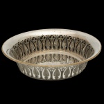 WMF - Centro de mesa em metal espessurado a prata alemão, repuxado e cinzelado. Laterais com recortes vazados geométricos e estilizados que formam padrões ornamentais semelhantes a palmetas. Fundo liso e espelhado no interior realça a lapidação. Borda superior revirada e lisa. No verso, marcas do metal e do fabricante WMF. 6 x 25 cm.
