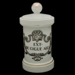 Pote de farmácia em vidro opalinado de formato cilíndrico, A inscrição "EXT. DE CIGUE ALC." refere-se a extrato de cicuta alcoólico, um composto farmacêutico histórico. 30 x 15 cm.