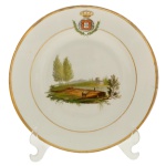 SERVIÇO REINO UNIDO PORTUGAL, BRASIL E ALGARVE - Prato em porcelana francesa, pertencente ao "Serviço do Reino Unido de Portugal, Brasil e Algarves". Encomendado no início do século XIX por ordem de D. João VI, este aparelho de jantar comemorava a elevação do Brasil à condição de Reino Unido em 16 de dezembro de 1815. Apresenta na aba o brasão do Reino Unido de Portugal, Brasil e Algarves sob a coroa real, ladeado por ramos de louro. Cada peça da coleção exibe uma pintura em policromia com paisagens rurais, rios, construções ou figuras integradas à natureza. Filetes dourados delicados contornam as bordas e a parte interna da aba.Pertenceu a coleção do Dr. Roque de Brito Alves  Recife e reproduzido no livro de sua coleção. Reproduzido na pág. 178 do livro Louça da Aristocracia no Brasil. 23 cm.