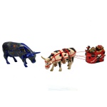 COWPARADE  Lote constando 2 figuras colecionáveis em miniatura da exposição CowParade, sendo:A) Figura em cerâmica da Westland, modelo "For Every New Year". 9 x 17 x 5 cm.B) Figura colecionável de vaca de Natal puxando trenó em resina da Westland Giftware. 8 x 27 x 5 cm.
