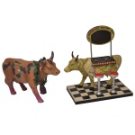 COWPARADE  Lote constando 2 figuras colecionáveis em miniatura da exposição CowParade, sendo:A) Figura colecionável da vaca "Harrisburg's Moo-tini Bar" de 2005 de Westland Giftware. 18 x 14 x 10 cm.B) Figura colecionável cerâmica modelo "Fine Wine Bovine", lançada em 2003. Apresentando uma vaca de cor castanha decorada com uvas e trepadeiras. Produzida pela Westland Giftware sob licença da CowParade Holdings Corporation. 11 x 16 x 5 cm.