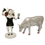 COWPARADE  Lote constando 2 figuras colecionáveis em miniatura da exposição CowParade, sendo:A) Figura colecionável da vaca modelo "Paraíso Tropical. 30 x 29 x 12 cm.B) Figura colecionável modelo Mira Moo na cor prata com acabamento em mosaico de espelho da artista Margaret Pedrotti para o evento de San Antonio em 2003.16 x 26 x 7 cm.