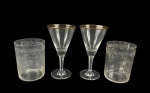 CRISTAIS, lote com quatro (4) peças confeccionadas em cristal translucido, sendo: A) SAINT LOUIS, par de copos em cristal francês translucido, ricamente lapidada por elementos vegetalistas em baixo relevo, medindo 9,5x7cm (1 com sinais de fungo) e B) 2 taças para vinho, bojo cônico, filetado a ouro, haste facetada apoiada sobre base circular, medindo 13,5x7cm.