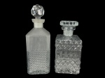 VIDROS, lote com duas (2) garrafas para whisky confeccionadas em vidro translúcido, sendo 1 moldada em bico de jaca e caneluras, fundo estrelado e tampa facetada, sinais de fungos, medindo 27cm de altura e 1 moldado por losangos e palmas, tampa adaptada, medindo 21cm de altura.