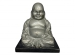 ESCULTURA, uma (1) escultura representando Buda sentado confeccionada em bronze com pintura prateada, apoiada sobre base retangular em pedra escura, apresentando falhas na pintura e ranhuras na pedra, medindo 22x9x15cm.