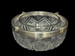 CRISTAL, um (1) porta caviar confeccionado em cristal translucido, ricamente lapidado por elementos geométricos, palmas e caneluras em baixo relevo com fundo estrelado, borda e grade em metal espessurado a prata, ausência do recipiente do caviar (central), medindo 10,5x23cm, falhas na prateação. Medida do encaixe do recipiente central 15,5cm.