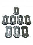 METAL PRATEADO, oito (8) espelho de fechadura confeccionados em metal prateado com recorte central para entrada de chave e furos para fixação, alguns com falhas na prateação, medindo 4x2cm.