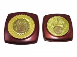 MEDALHAS, duas (2) medalhas em bronze, de premiação, aplicadas sobre bases em tom vinho, com relevos decorativos representando figuras alegóricas e medalhão central. Uma das peças apresenta gravação no verso com inscrição: 1ª Exp. Quadros Famosos, XXIV R.A. B. Tijuca, Delfin Ag. Carrefour, 1º lugar, 79, acondicionadas em estojos em plástico na cor marrom, medem 5cm e 4cm.