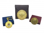 MEDALHAS, três (3) peças comemorativas, sendo: a) uma (1) medalha/chaveiro da Sociedade Acadêmica da Marinha Mercante, em metal dourado, com brasão esmaltado e estojo, medindo 3,5cm, B) uma (1) medalha / plaqueta da Força Aérea Brasileira  III COMAR, alusiva ao Salão Regional de Artes Plásticas de 1982, acondicionada em capa/estojo plastico, medindo 6cm e C) uma (1) medalha comemorativa em bronze ligada à Academia de Ciências e Artes, com relevo de figura clássica e estojo, medindo 4cm.