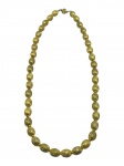 BIJUTERIA, um (1) colar com contas ovais texturizadas confeccionados em metal dourado, com fecho tipo gaveta representando flor. Peça com sinais de uso e falhas na douração, medindo 60cm de comprimento.