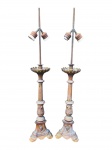 ABAJURES, par (2) de tocheiros adaptados para abajur de duas lâmpadas confeccionados em bronze, com fustes altos de corpo canelado e bocéis torneados. Bases de feição neobarroca, ricamente ornamentadas em relevo, com reservas apresentando imagens do Sagrado Coração de Jesus e do Sagrado Coração de Maria, ladeadas por volutas, folhas estilizadas e elementos concheados. Peças de forte caráter decorativo e litúrgico, apresentando sinais de oxidação e falhas na douração do bronze, ausência dos acabamentos superiores, medindo 77cm de altura.