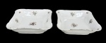 MZ Moritz Zdekauer (Produzida após 1918, ano da independência da Checoslováquia), par (2) de travessas quadrangulares e fundas confeccionadas em porcelana theca na tonalidade branca, decorada por flores e folhagens em policromia, realces vegetalistas em relevo na pasta e filete em ouro na borda, apresenta falhas na douração, medindo 6x22,5x22,5cm.