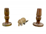 DIVERSOS, lote com três (3) peças confeccionadas em pedra sabão, sendo: A) par de castiçais, corpo torneado e base circular, medindo 10,5cm de altura e B) 1 escultura representando tatu, medindo 4,5x11x2,5cm.