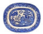 Enoch Burn & John Edwin Leach, uma (1) travessa em fainça vitrificada com decoração na técnica BLUE and WHITE, executada em formato retangular com extremidades arredondadas. Borda decorada com elementos geométricos e fitomórficos. Caldeira decorada com paisagem oriental, edificações e personagens que dão origem ao conto dos "pombinhos", medindo 39x32cm. (A parceria entre Bourne e Leigh foi estabelecida em 1892 em Burslem, na famosa região de Stoke-on-Trent, o coração da indústria de cerâmica na Inglaterra).