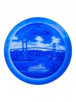 SIGAL BROTHERS LTD, um (1) prato decorativo confeccionado em porcelana, de origem japonesa, produzido como lembrança turística das Mil Ilhas  Canadá. Apresenta decoração monocromática em azul, com representação de ponte suspensa, embarcação e paisagem arborizada, além da inscrição 1000 Islands Canada, medindo 21,5cm.