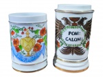 PORCELANAS, dois (2) potes de farmácia, confeccionados em porcelana na tonalidade branca, em formato cilíndrico, ambos sem tampas, decorados à mão com motivos florais, elementos heráldicos e filetes dourados. Apresentam inscrições farmacêuticas BEUR: CACAO e POM: CALOM:, referentes a preparações de manteiga de cacau e pomada de calomel. Peças de caráter decorativo e colecionável, assinadas no verso, medindo 17x11cm e 20x10cm.