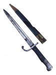 MILITARIA, uma (1) baioneta Mauser M908 (Fabrica Weyersberg Kirschbaum & Cie Solingen), lâmina em aço carbono, cabo em madeira com quebra, sinais de oxidação na lâmina e bainha em couro com desgaste, medindo 46cm de comprimento.
