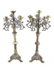 BRONZES, par (2) de candelabros para seis velas confeccionadas em bronze com braços curvos ricamente cinzelado por arabescos e pinhas, haste cilíndrica com torneado vegetalista, apoiada sobre base tripoide com perolados, folhagens em vazados com pés finalizados em cabeças de bicho, apresenta leves mossas e sinais de oxidação, medindo 60,5cm de altura.