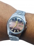 RELÓGIO, um (1) relógio de pulso vintage, da marca Orient, referência H469658A-6A PR, com mecanismo automático de 21 rubis, caixa e pulseira em aço inoxidável, mostrador fumê em tons de vinho e castanho, marcadores de horas aplicados, calendário duplo indicando dia da semana e data às 3 horas e duas coroas laterais. Tampa posterior com inscrições, sinais de uso, funcionando, porém, sem garantia futura, caixa medindo 3,5cm.