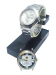 RELÓGIOS, dois (2) relógios de pulso, sendo: A) da marca Swatch, de fabricação suíça, com mecanismo quartz, caixa e pulseira em aço prateado adaptado da marca TECHNOS, com tampa traseira, também, adaptada, mostrador claro com três submostradores e marcadores aplicados, apresentando manchas, riscos e desgastes no visor, caixa medindo 4cm e B) 1 com inscrição e logomarca TAG Heuer no mostrador, mecanismo quartz, caixa em aço prateado com detalhes dourados, mostrador claro recortado com marcadores verdes, sem pulseira, verso com inscrições Stainless Steel Back, Water Resistant e Swiss Movt, apresentando sinais de uso e desgastes, possivelmente trata-se de uma réplica, medindo 3,5cm. Ambos com funcionamento não testado e sem garantia, vendidos no estado da foto.