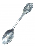 COLECIONISMO, uma (1) colher souvenir em metal prateado, da Rolex Bucherer Watches, Zürich, com cabo ornamentado em relevo trazendo brasão e inscrições da marca, e concha decorada com vista arquitetônica da cidade de Zurique, Suíça, pequena mossa no cabo.