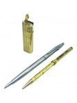 CANETAS e METAL DOURADO, três (3) peças, sendo: A) um isqueiro de bolso da marca Sunex, em metal dourado, com corpo retangular texturizado e acionamento superior; B) uma caneta esferográfica em metal dourado, com corpo trabalhado e decoração esmaltada em formato de flecha; C) uma caneta esferográfica em metal prateado, com clipe lateral e pequeno visor digital incorporado ao corpo. Peças usadas, apresentando riscos, manchas, oxidação, desgastes e sinais do tempo. Cargas, visor e funcionamento do isqueiro não testados. Vendidas no estado.