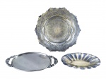 METAL PRATEADO, lote com três (3) peças confeccionadas em metal espessurado a prata, sendo: A) 1 fruteira com rico cinzelado vegetalista em vazados com ondulações na borda e base escalonada, medindo 5,5x25cm, falhas na prateação, B) 1 bandeja oval, fundo liso e alças no feitio de arabescos em vazados, medindo 26x12cm e C) 1 pequena petisqueira oval com falhas na prateação e mossa, medindo 18x10cm.