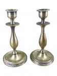 BRONZES, par (2) de castiçais confeccionados em bronze com vestígios de banho de prata, corpo balaustre, base circular cinzelada por frisos torcidos com bobeche torneada, medindo 12,5cm de altura.