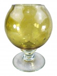 MURANO, um (1) vaso confeccionado em vidro de Murano na tonalidade amarela decorada por bulicantes internos, haste torneada apoiada sobre base circular translúcida, medindo 24x12cm.