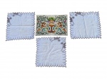 CAMA, MESA & BANHO, lote com quatro (4) peças, sendo: A) três guardanapos quadrangulares com bordas recortadas e bordados florais em tons de marrom, medino 39x39cm e B) um pano de bandeja retangular ricamente bordado com vaso central, folhagens, animais e figuras aladas em composição policromada, medindo 43x30cm.