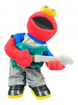 COLECIONISMO, um (1) boneco infantil do personagem Elmo, em tecido/plush e material plástico, trajando roupa em tecido e segurando guitarra plástica colorida. Peça com sapatos em plástico, com compartimento para pilhas, não testado e sem garantia de funcionamento, apresenta sujidades e marcas de uso, medindo 32cm de altura.
