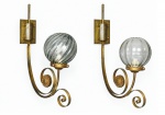 LUMINÁRIAS, par (2) de arandelas confeccionadas em metal dourado, com hastes curvas em volutas, placa de fixação retangular, ornamento circular em relevo e cúpulas globulares em vidro translucido, medindo 62x54cm.