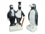 ESCULTURAS, duas (2) esculturas representando pinguins confeccionadas em faiança vitrificada na tonalidade branca com pintura na tonalidade preta, ambas com falhas na pintura, medindo 25cm e menor 24,5cm.